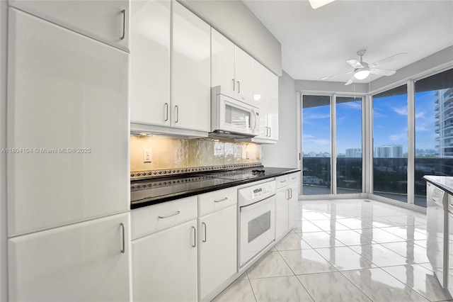 3200 N Ocean Blvd Unit 1206, Fort Lauderdale, FL 33308 - kitchen with white appliances, backsplash, ceiling fan, white cabinets, and dark countertops