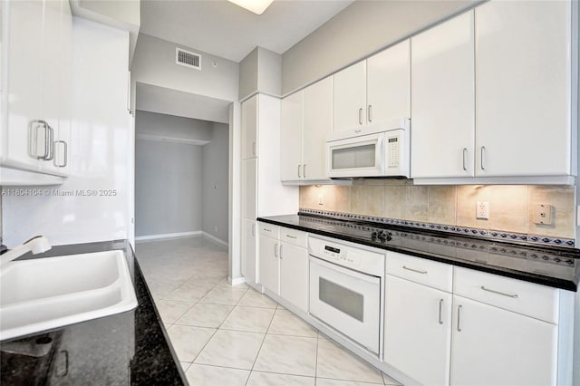 3200 N Ocean Blvd Unit 1206, Fort Lauderdale, FL 33308 - kitchen featuring white appliances, a sink, tasteful backsplash, dark countertops, and white cabinets