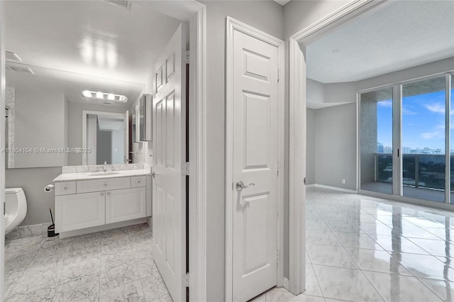 3200 N Ocean Blvd Unit 1206, Fort Lauderdale, FL 33308 - bathroom with marble look tile flooring, baseboards, toilet, and vanity