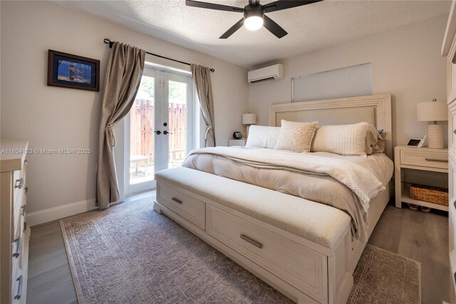 22226 SW 65th Ter, Boca Raton, FL 33428 - bedroom featuring an AC wall unit, access to outside, a textured ceiling, baseboards, and wood finished floors