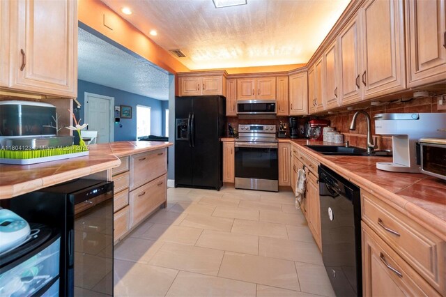 22226 SW 65th Ter, Boca Raton, FL 33428 - kitchen featuring black appliances, tile counters, a sink, light tile patterned flooring, and backsplash