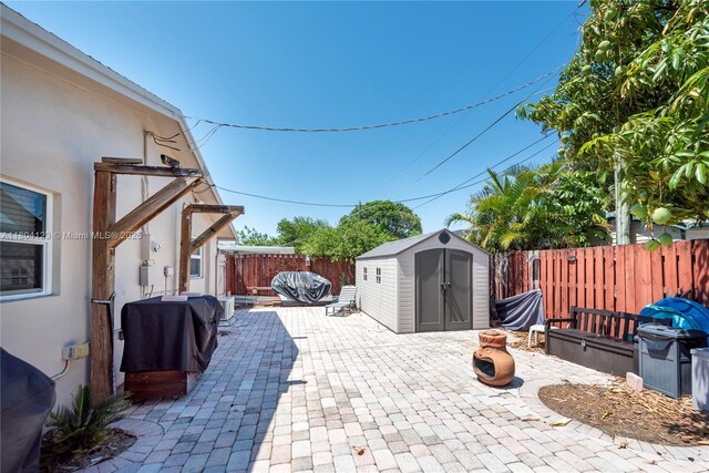 22226 SW 65th Ter, Boca Raton, FL 33428 - view of patio with a storage shed, a fenced backyard, and an outbuilding