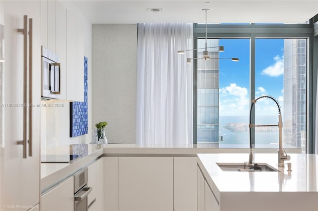 88 SW 7th St Unit 4101, Miami, FL 33130 - kitchen with white cabinetry, a water view, a sink, light countertops, and appliances with stainless steel finishes
