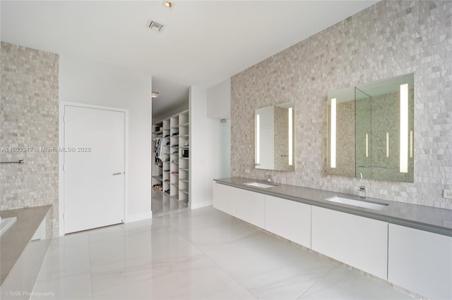 88 SW 7th St Unit 4101, Miami, FL 33130 - bathroom with double vanity, a spacious closet, decorative backsplash, and a shower with shower door