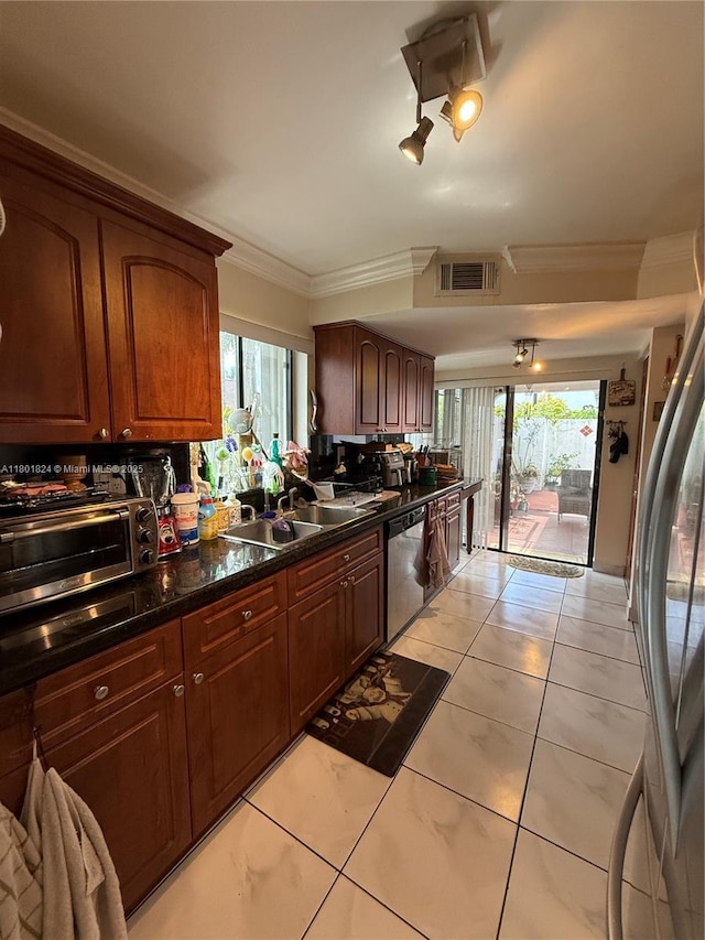 kitchen featuring appliances with stainless steel finishes, crown molding, a sink, and dark countertops