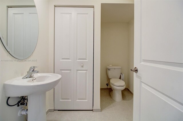 11094 W 33rd Way, Hialeah, FL 33018 - bathroom featuring tile patterned flooring, toilet, baseboards, and a sink