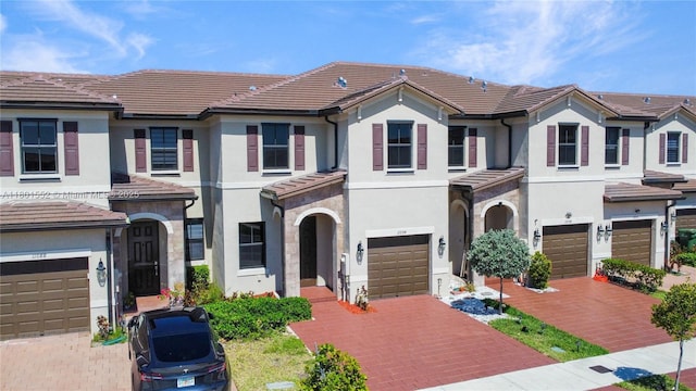 11094 W 33rd Way, Hialeah, FL 33018 - townhome / multi-family property featuring driveway, an attached garage, a tile roof, and stucco siding