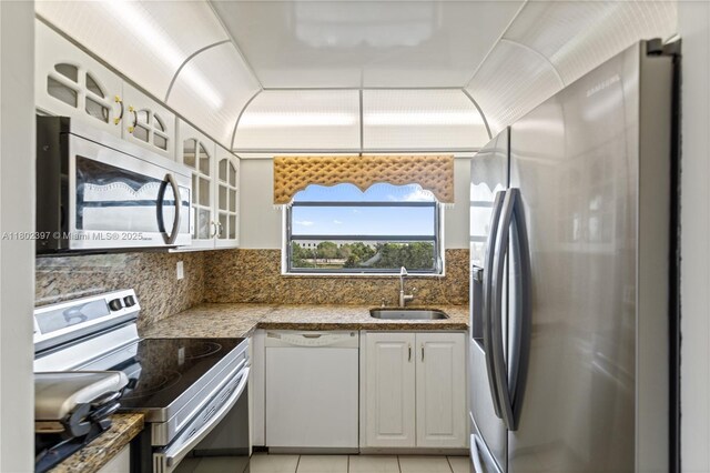 900 Colony Point Cir Unit 523, Pembroke Pines, FL 33026 - kitchen featuring appliances with stainless steel finishes, glass insert cabinets, light tile patterned flooring, backsplash, and white cabinets