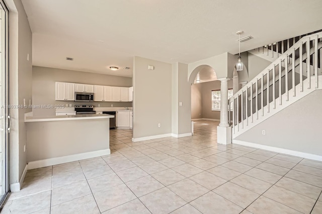 17668 SW 135th Ct, Miami, FL 33177 - kitchen featuring stainless steel appliances, light tile patterned flooring, arched walkways, and light countertops