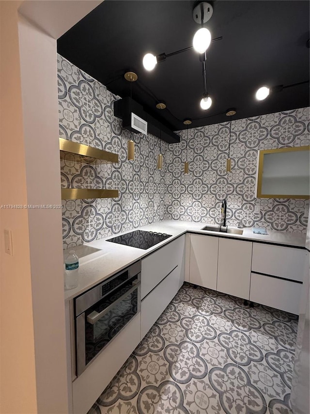 3209 S Ocean Dr Unit 2M, Hallandale Beach, FL 33009 - kitchen featuring stainless steel oven, black electric stovetop, a sink, white cabinets, and light countertops