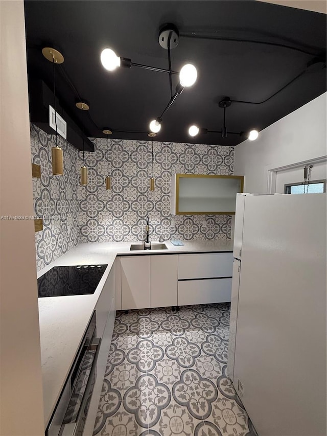 3209 S Ocean Dr Unit 2M, Hallandale Beach, FL 33009 - kitchen with freestanding refrigerator, a sink, white cabinetry, light countertops, and black electric stovetop