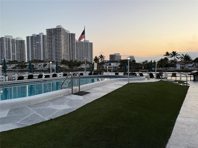 3209 S Ocean Dr Unit 2M, Hallandale Beach, FL 33009 - pool at dusk with a community pool and a yard