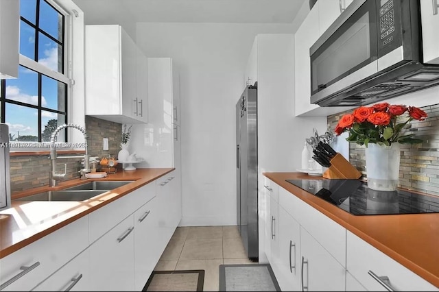 12202 SW 216th St, Miami, FL 33170 - kitchen with appliances with stainless steel finishes, a sink, backsplash, and white cabinetry