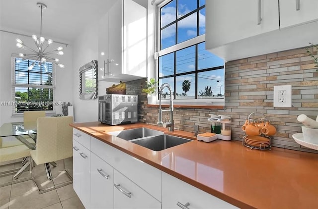 12202 SW 216th St, Miami, FL 33170 - kitchen with a sink, decorative backsplash, white cabinets, and light tile patterned flooring