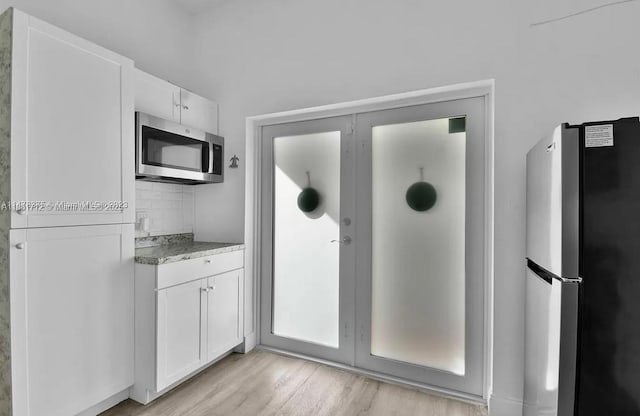 12202 SW 216th St, Miami, FL 33170 - kitchen with appliances with stainless steel finishes, white cabinetry, light wood-style flooring, and light stone countertops
