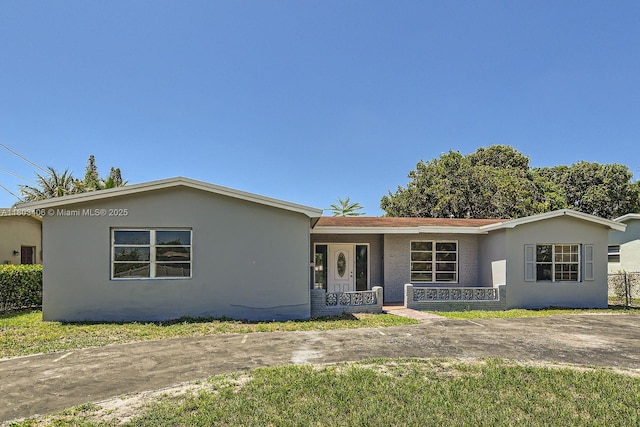 3226 NW 41st St, Lauderdale Lakes, FL 33309 - ranch-style house with a porch, brick siding, stucco siding, and a front yard