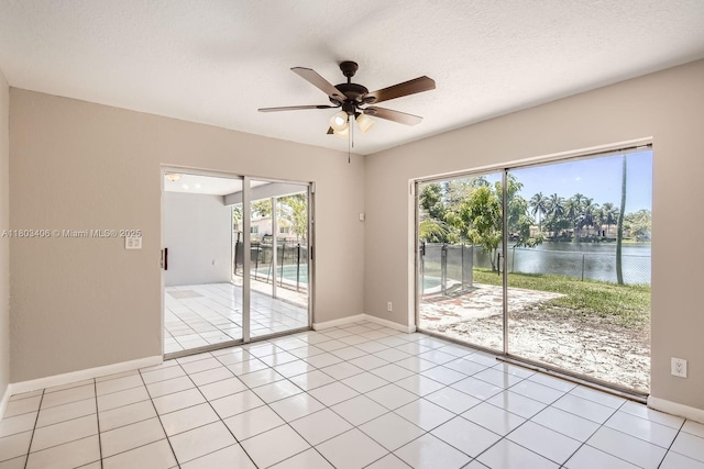 3226 NW 41st St, Lauderdale Lakes, FL 33309 - empty room featuring ceiling fan, baseboards, healthy amount of natural light, a water view, and a textured ceiling