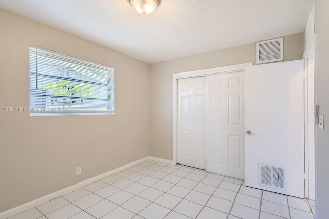 3226 NW 41st St, Lauderdale Lakes, FL 33309 - unfurnished bedroom featuring a closet, baseboards, and light tile patterned floors