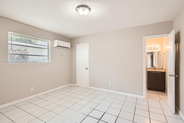 3226 NW 41st St, Lauderdale Lakes, FL 33309 - unfurnished bedroom with a wall mounted air conditioner, baseboards, a textured ceiling, light tile patterned floors, and a sink