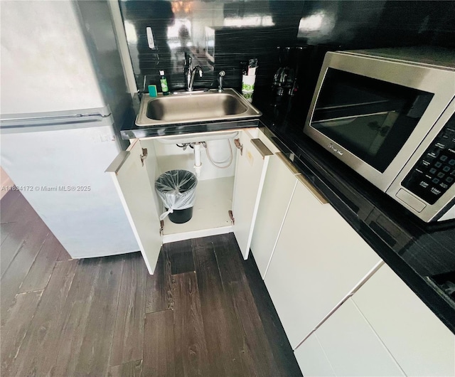 6345 Collins Ave Unit 818, Miami Beach, FL 33141 - detailed view of stainless steel microwave, a sink, freestanding refrigerator, and dark wood-type flooring