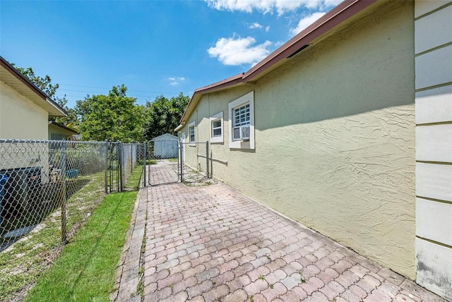 4240 NW 22nd St, Lauderhill, FL 33313 - view of side of home featuring stucco siding, a patio area, cooling unit, and a gate