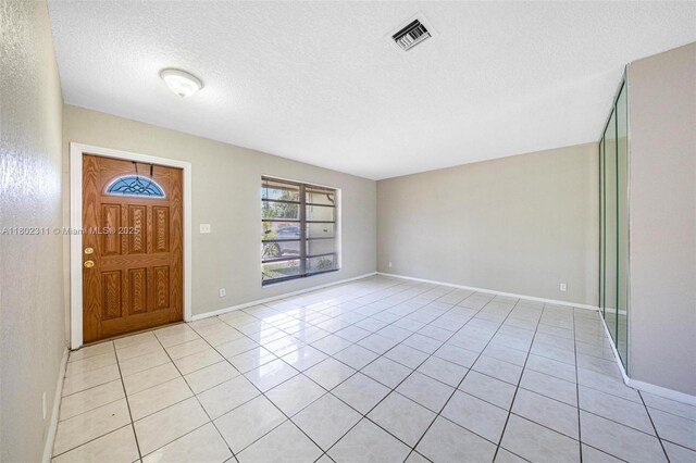 4240 NW 22nd St, Lauderhill, FL 33313 - foyer featuring light tile patterned flooring, a textured ceiling, and baseboards
