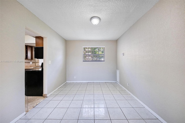 4240 NW 22nd St, Lauderhill, FL 33313 - spare room featuring a textured ceiling, light tile patterned floors, and baseboards