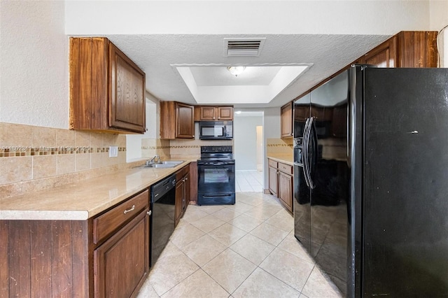 4240 NW 22nd St, Lauderhill, FL 33313 - kitchen featuring black appliances, a sink, a tray ceiling, light countertops, and a textured ceiling