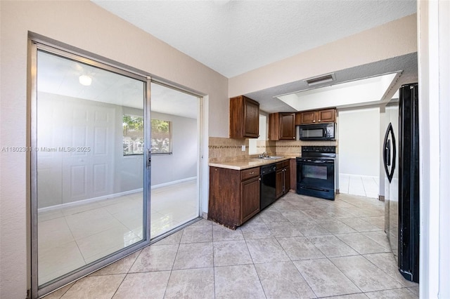 4240 NW 22nd St, Lauderhill, FL 33313 - kitchen with black appliances, a sink, light countertops, light tile patterned floors, and baseboards