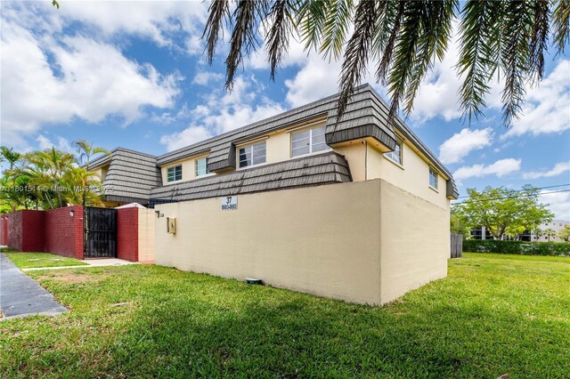8693 SW 137th Ave Unit 8693, Miami, FL 33183 - view of home's exterior with a gate, mansard roof, and stucco siding