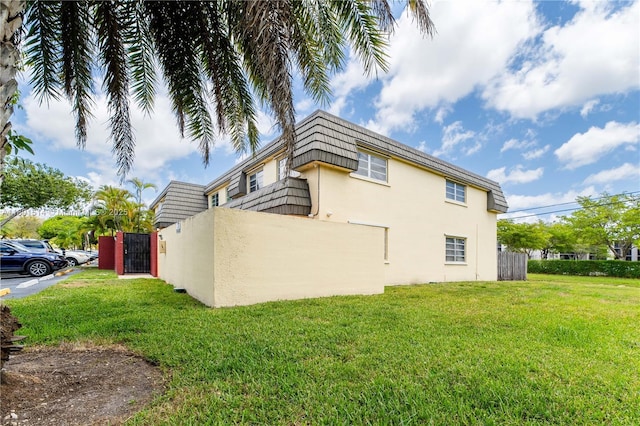 8693 SW 137th Ave Unit 8693, Miami, FL 33183 - view of home's exterior featuring mansard roof, stucco siding, and a lawn