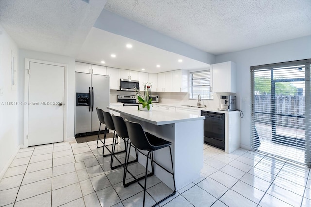 8693 SW 137th Ave Unit 8693, Miami, FL 33183 - kitchen with stainless steel appliances, a breakfast bar area, a textured ceiling, light countertops, and white cabinets