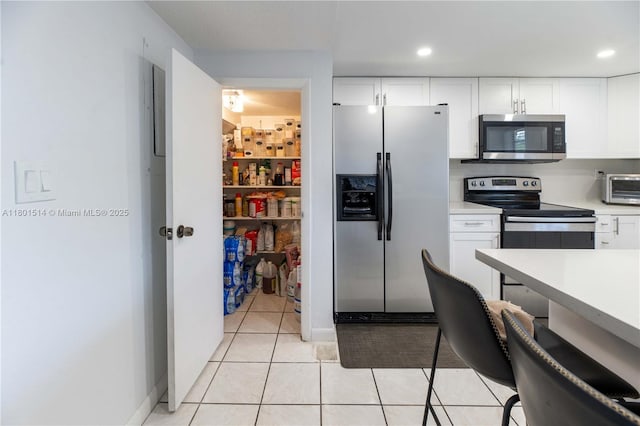8693 SW 137th Ave Unit 8693, Miami, FL 33183 - kitchen with stainless steel appliances, white cabinets, light countertops, light tile patterned flooring, and recessed lighting