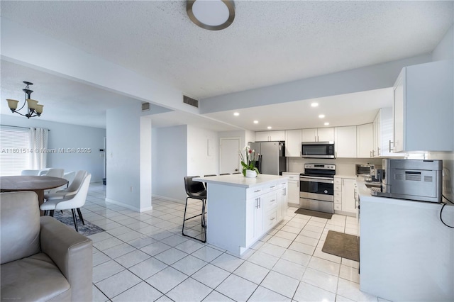 8693 SW 137th Ave Unit 8693, Miami, FL 33183 - kitchen featuring appliances with stainless steel finishes, a breakfast bar area, a center island, recessed lighting, and light tile patterned floors