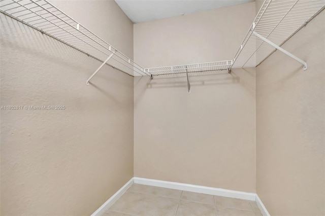 6077 Azalea Cir, West Palm Beach, FL 33415 - walk in closet with light tile patterned floors