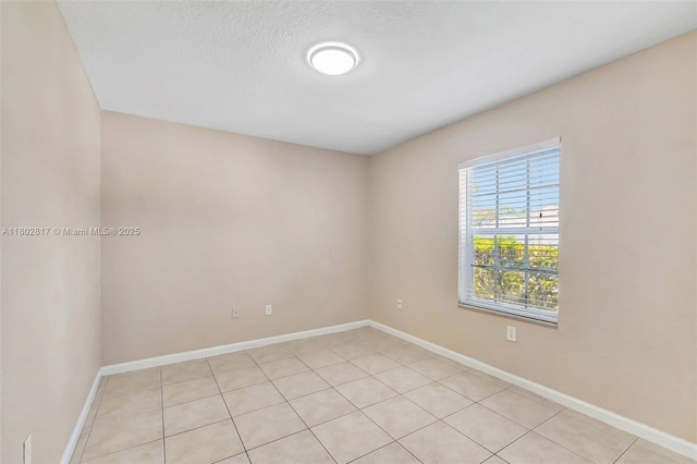 6077 Azalea Cir, West Palm Beach, FL 33415 - spare room with baseboards, light tile patterned floors, and a textured ceiling