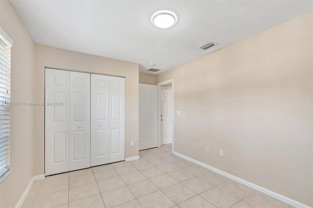 6077 Azalea Cir, West Palm Beach, FL 33415 - unfurnished bedroom featuring baseboards, a closet, and light tile patterned floors