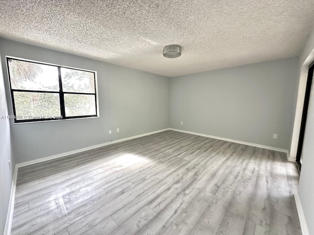 601 Ives Dairy Rd Unit 401-8, Miami, FL 33179 - spare room featuring wood finished floors, a textured ceiling, and baseboards