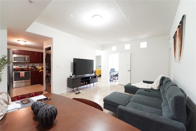 5271 SW 8th St Unit 311, Miami, FL 33134 - living room with stacked washer and clothes dryer, light tile patterned floors, a textured ceiling, and baseboards