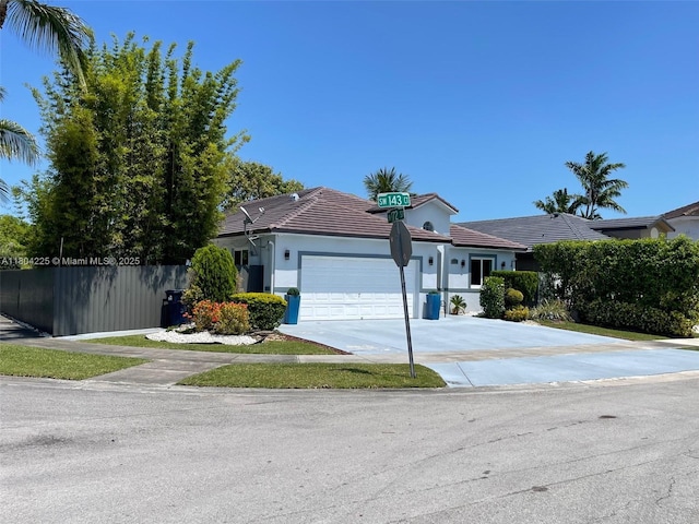 17201 SW 143rd Ct, Miami, FL 33177 - ranch-style house with fence, a garage, concrete driveway, stucco siding, and a tile roof