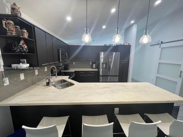 17201 SW 143rd Ct, Miami, FL 33177 - kitchen with appliances with stainless steel finishes, a sink, a peninsula, light countertops, and hanging light fixtures