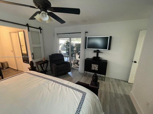 17201 SW 143rd Ct, Miami, FL 33177 - bedroom with a barn door, wood finished floors, access to exterior, baseboards, and ceiling fan