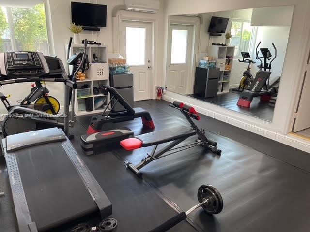 17201 SW 143rd Ct, Miami, FL 33177 - exercise room featuring an AC wall unit and healthy amount of natural light