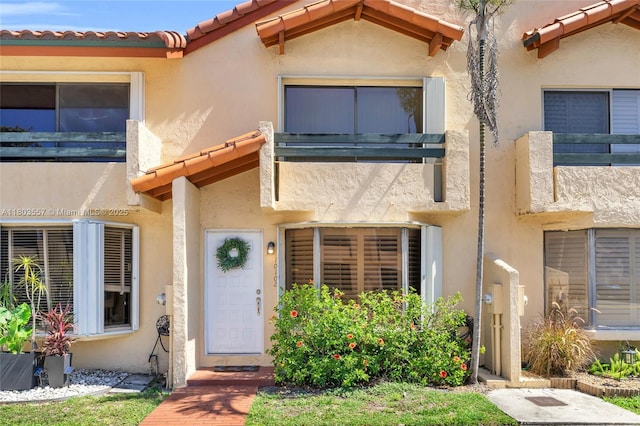 entrance to property featuring stucco siding and a tiled roof