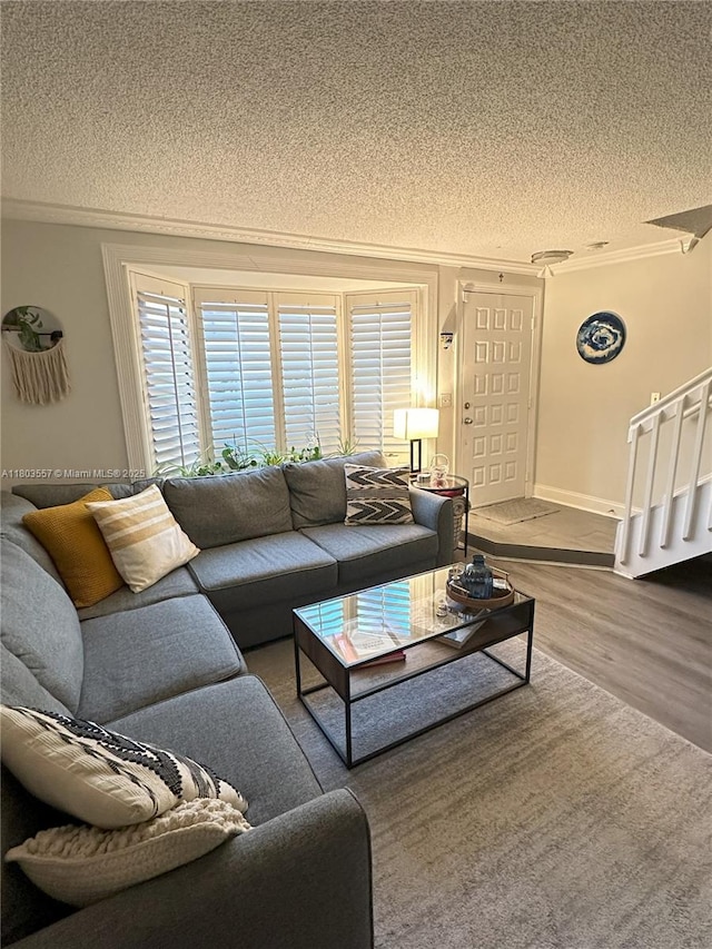 living room featuring a textured ceiling, wood finished floors, and ornamental molding