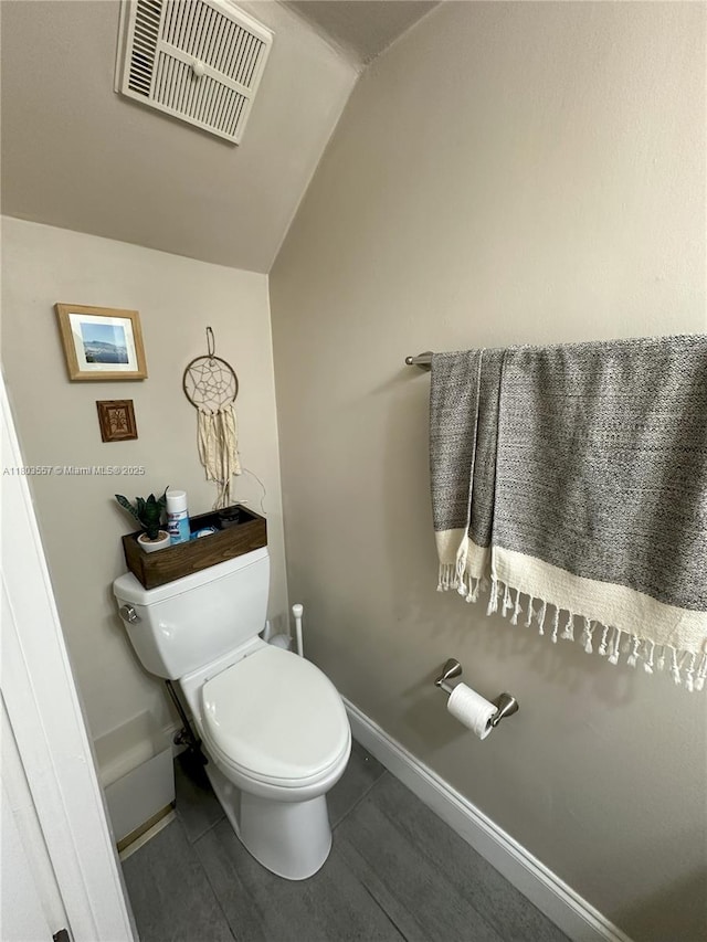 bathroom with lofted ceiling, toilet, tile patterned floors, and baseboards