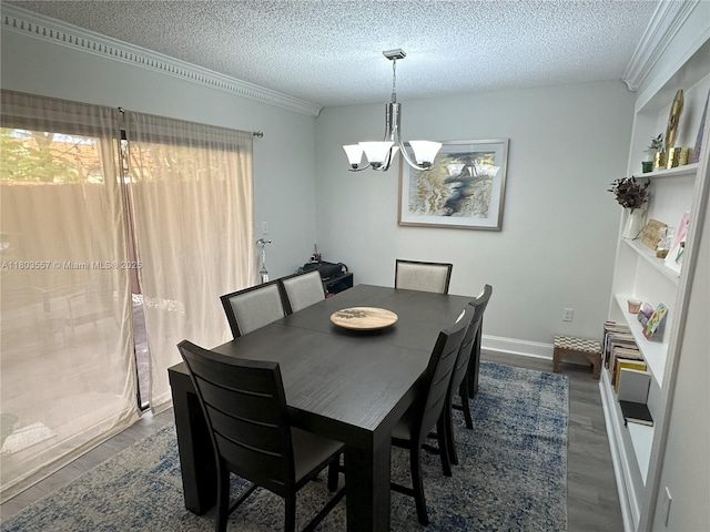 dining room featuring a chandelier, dark wood-style flooring, a textured ceiling, ornamental molding, and baseboards
