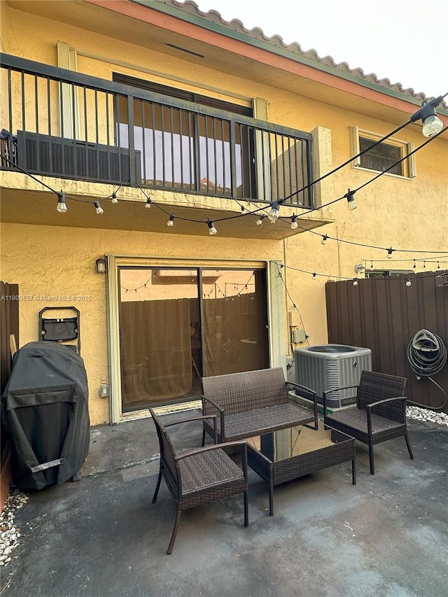 view of patio with a balcony, central AC unit, and a grill