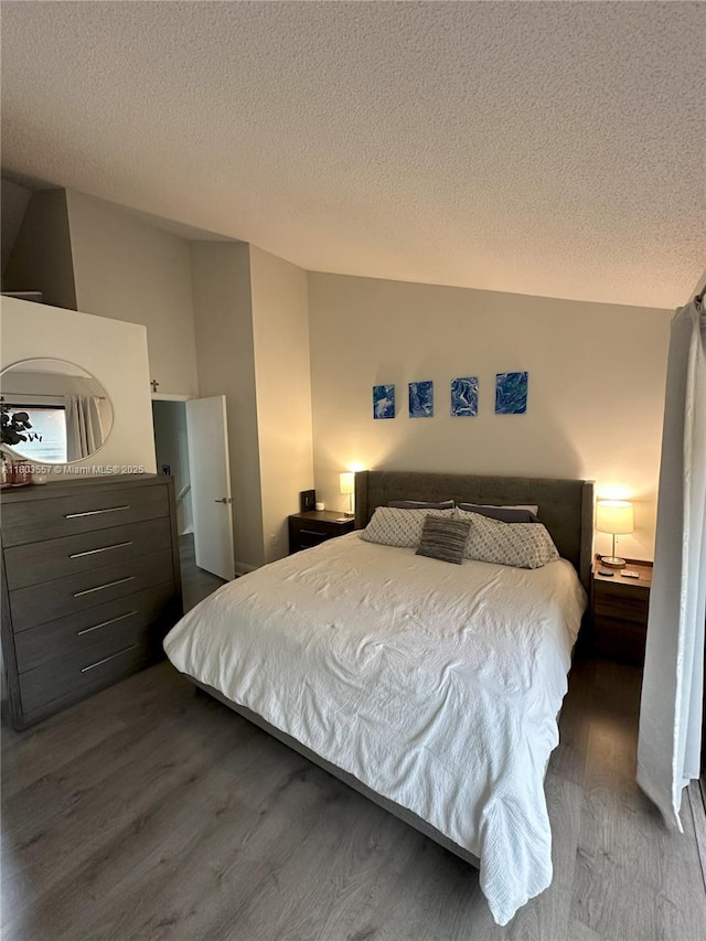 bedroom featuring wood finished floors and a textured ceiling