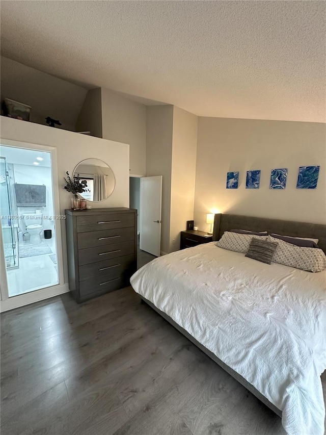 bedroom with dark wood-style flooring, a textured ceiling, and lofted ceiling